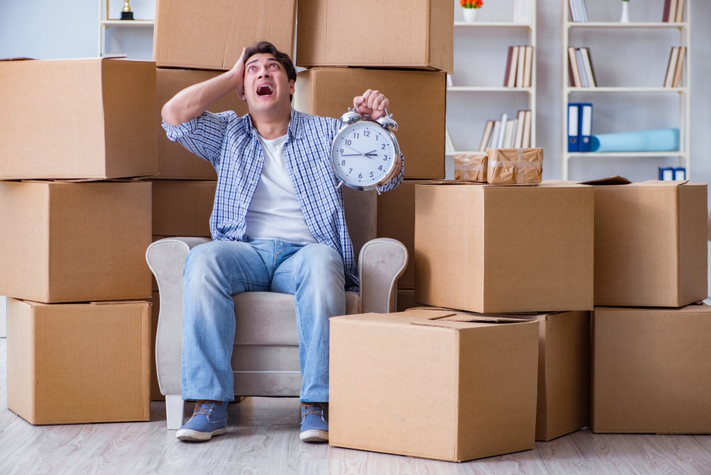 Young man moving in to new house with boxes